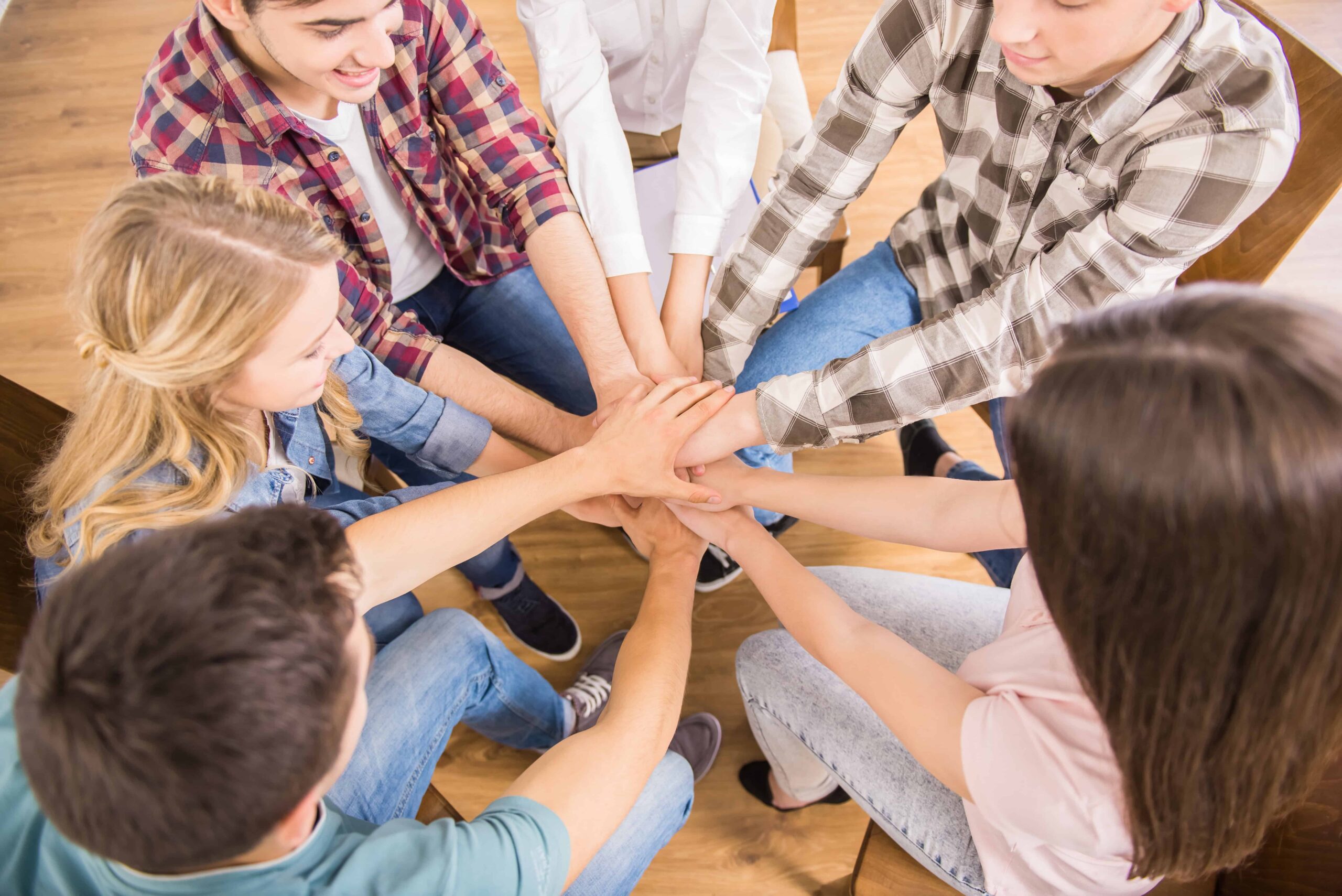 group people sitting circle supporting each other scaled