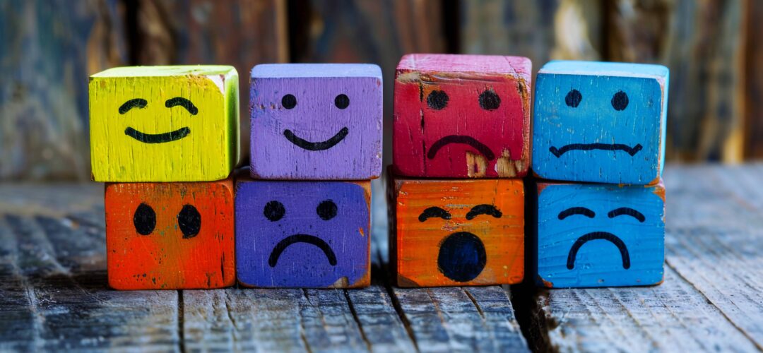 colorful wooden cubes with different happy sad faces them sitting each other