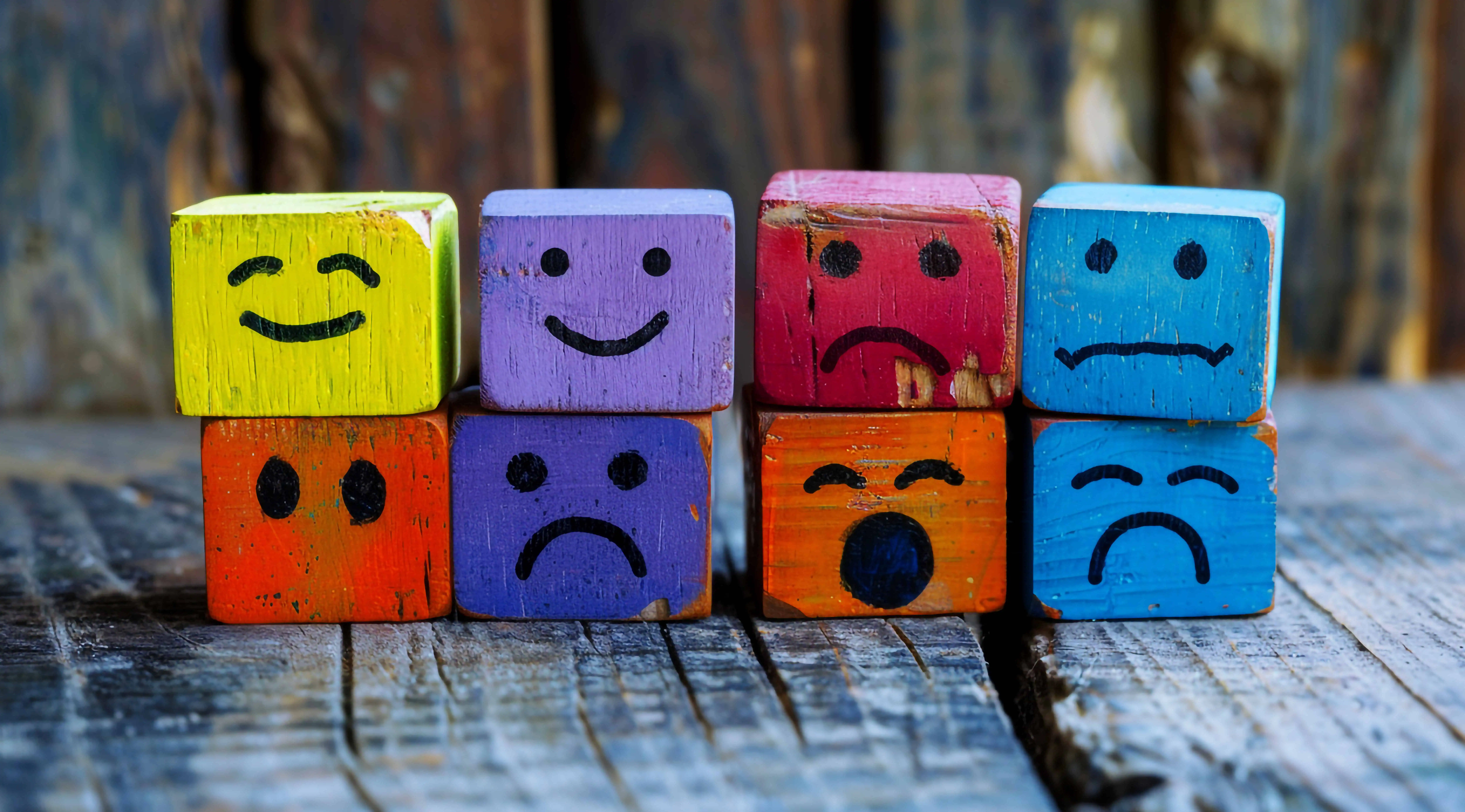 Effektive Schwerpunktsetzung in der Schulentwicklung: Emotionale Kompetenzen nachhaltig stärken 1 colorful wooden cubes with different happy sad faces them sitting each other